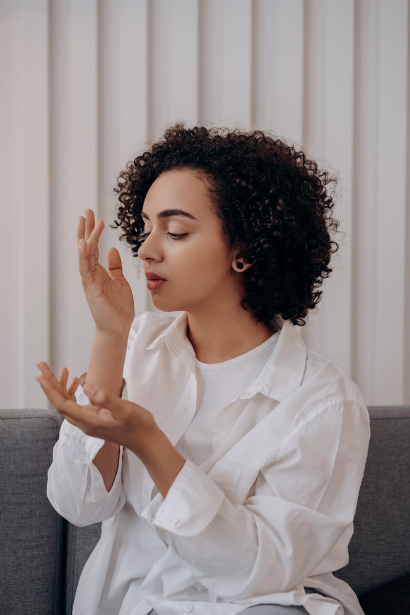 Woman in White Dress Shirt Smelling Her Hand